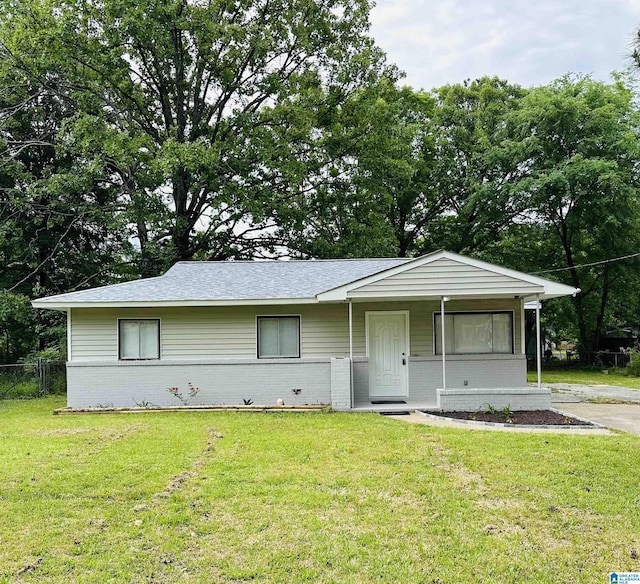 view of front of property with brick siding, fence, and a front yard