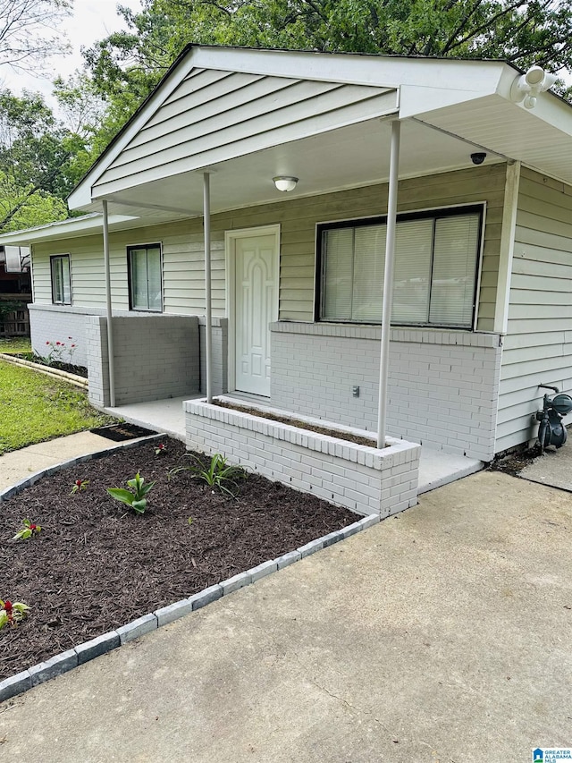 view of front of home with a porch and brick siding