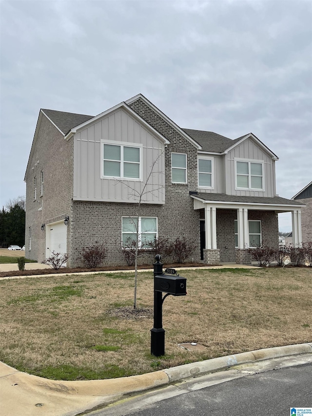 view of front of property featuring board and batten siding, brick siding, an attached garage, and a front lawn