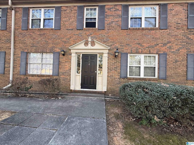 doorway to property with brick siding