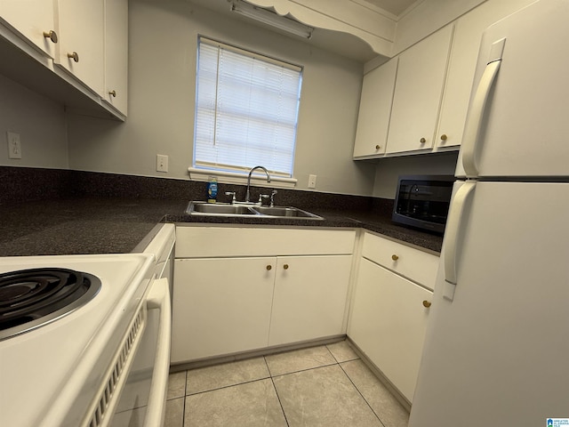 kitchen featuring white appliances, dark countertops, a sink, and white cabinets