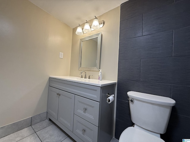 half bath featuring toilet, vanity, and tile patterned floors