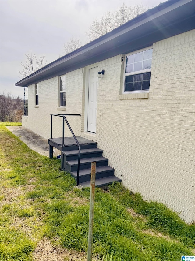 doorway to property featuring a lawn