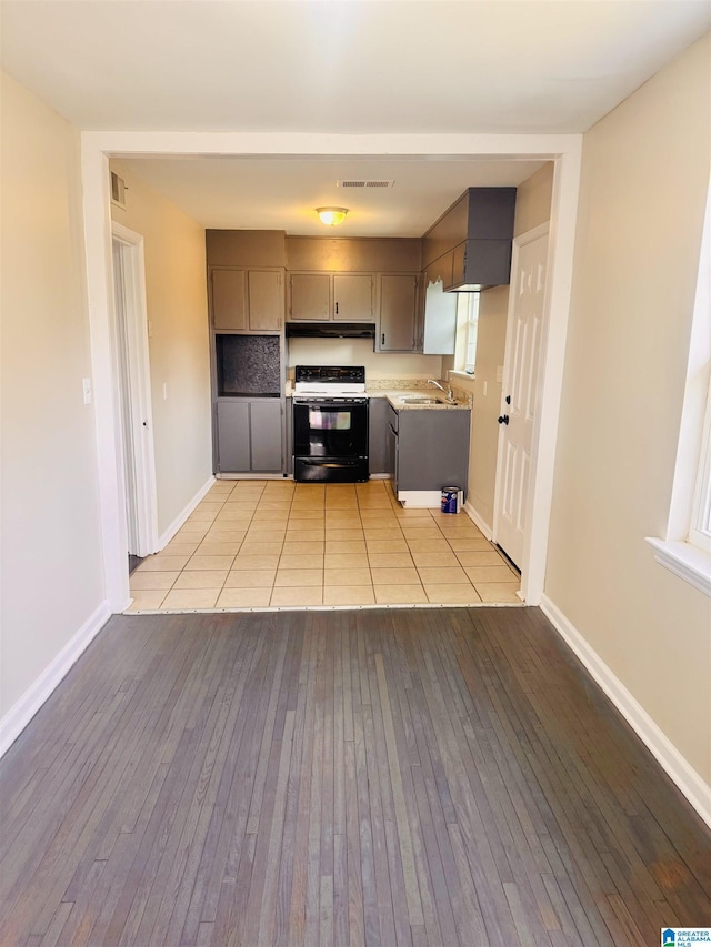 kitchen with visible vents, black / electric stove, light countertops, and gray cabinetry