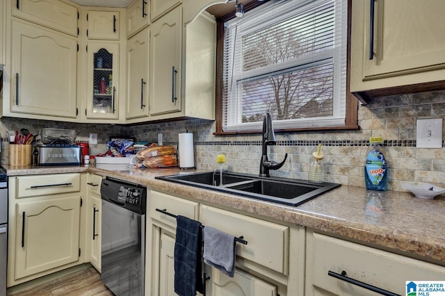 kitchen with decorative backsplash, dishwasher, light countertops, a healthy amount of sunlight, and a sink