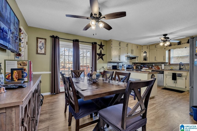 dining space with ceiling fan, a textured ceiling, and baseboards