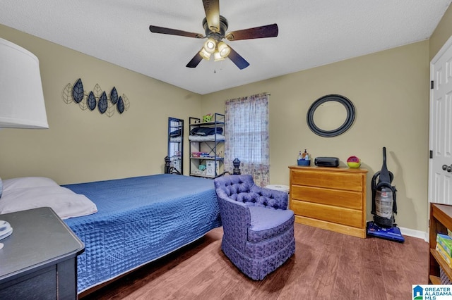 bedroom featuring a textured ceiling, wood finished floors, and a ceiling fan