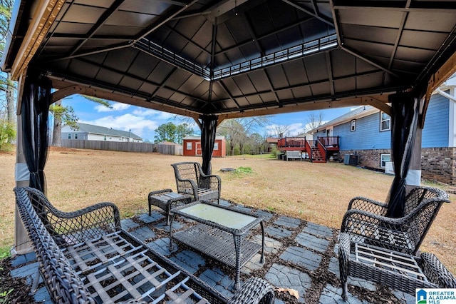 view of patio / terrace featuring a storage shed, stairway, an outbuilding, fence, and a gazebo