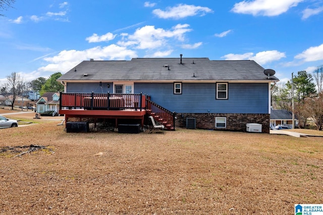 back of property featuring central AC unit, stairway, a deck, and a yard