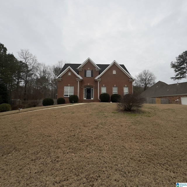 traditional-style house featuring a front yard and brick siding