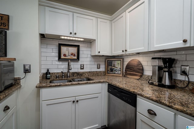 kitchen with dark stone counters, a sink, white cabinetry, backsplash, and dishwasher