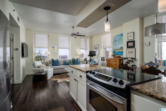 kitchen with decorative light fixtures, open floor plan, white cabinetry, stainless steel range with electric stovetop, and dark stone counters