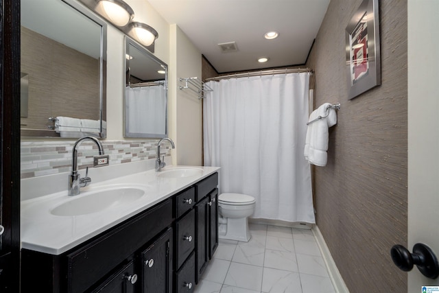 full bath with double vanity, marble finish floor, decorative backsplash, and a sink