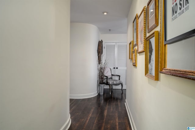 hallway with dark wood-style floors and baseboards