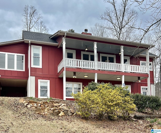 view of front of house with ceiling fan, board and batten siding, and a balcony