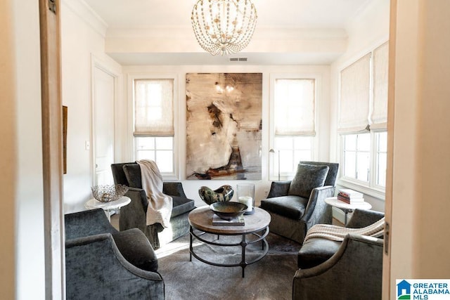 sitting room featuring visible vents, crown molding, and an inviting chandelier