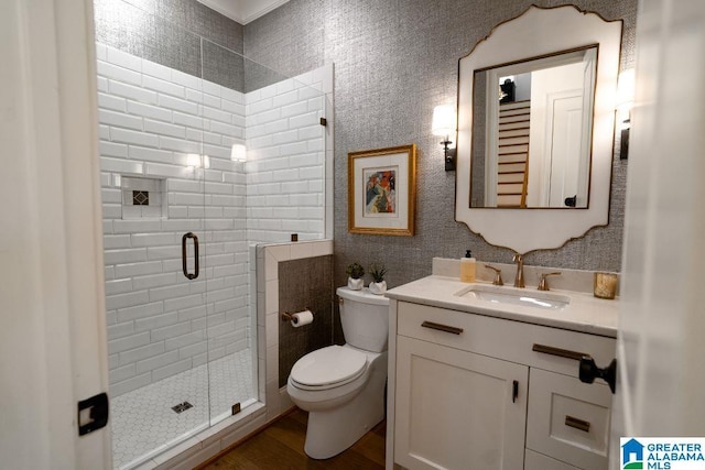 bathroom with a stall shower, vanity, toilet, and wood finished floors