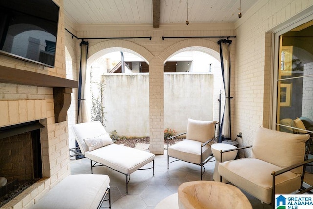 view of patio with an outdoor brick fireplace and fence