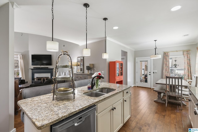 kitchen with light stone counters, a kitchen island with sink, a sink, open floor plan, and dishwasher