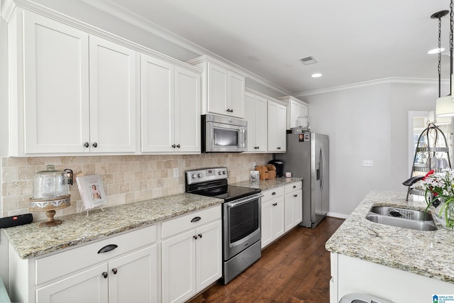 kitchen featuring decorative light fixtures, stainless steel appliances, visible vents, white cabinets, and a sink