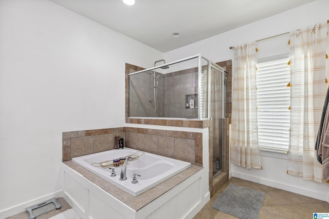 full bathroom featuring a stall shower, tile patterned flooring, baseboards, and a bath