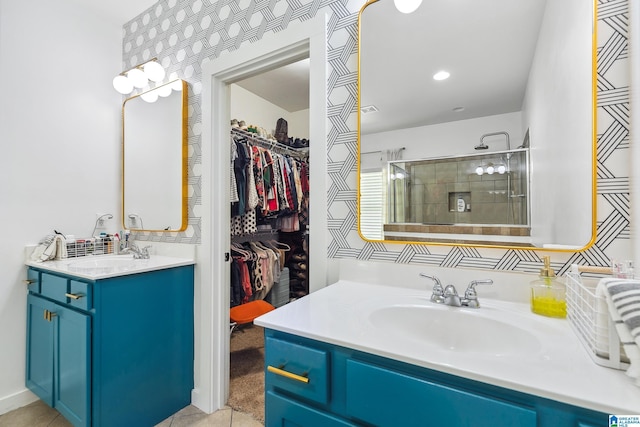 full bathroom featuring tile patterned flooring, a tile shower, vanity, and a spacious closet