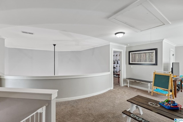 corridor with attic access, carpet, visible vents, and crown molding