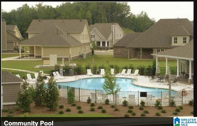 pool with a patio area and fence