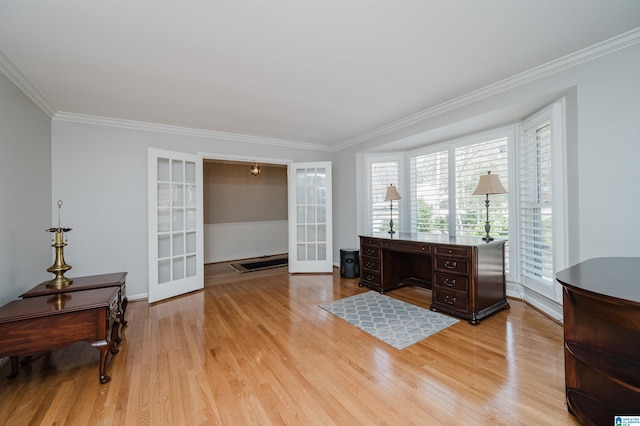 home office featuring light wood-style flooring, ornamental molding, and french doors