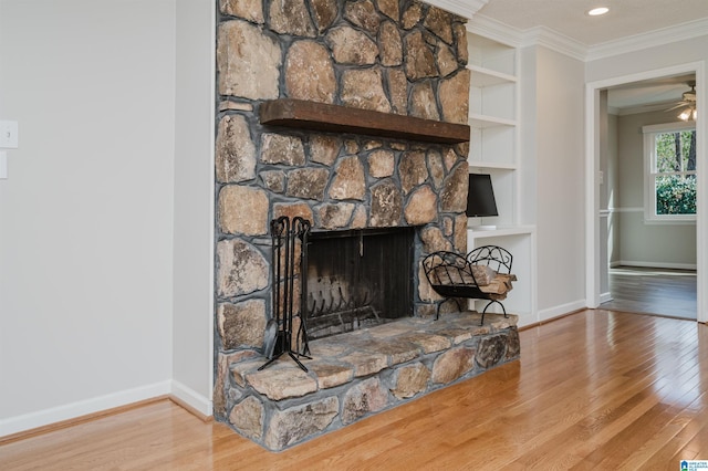 details featuring built in shelves, a fireplace, crown molding, wood finished floors, and baseboards