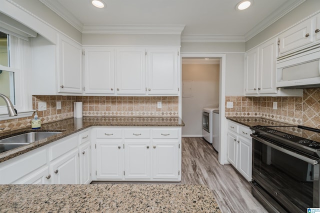 kitchen with electric stove, separate washer and dryer, white microwave, and white cabinets