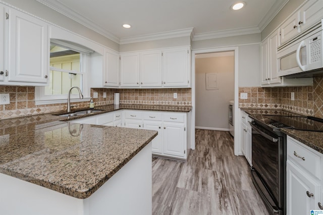 kitchen featuring white microwave, a sink, white cabinetry, black electric range, and dark stone counters