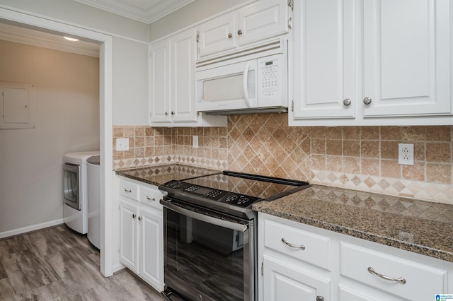 kitchen with range with electric stovetop, washer and clothes dryer, white microwave, white cabinetry, and dark stone countertops