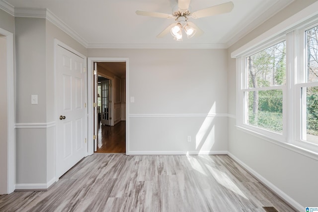 unfurnished room featuring light wood-style floors, ornamental molding, baseboards, and ceiling fan