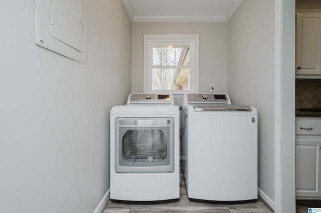 washroom featuring laundry area, ornamental molding, washing machine and clothes dryer, and baseboards