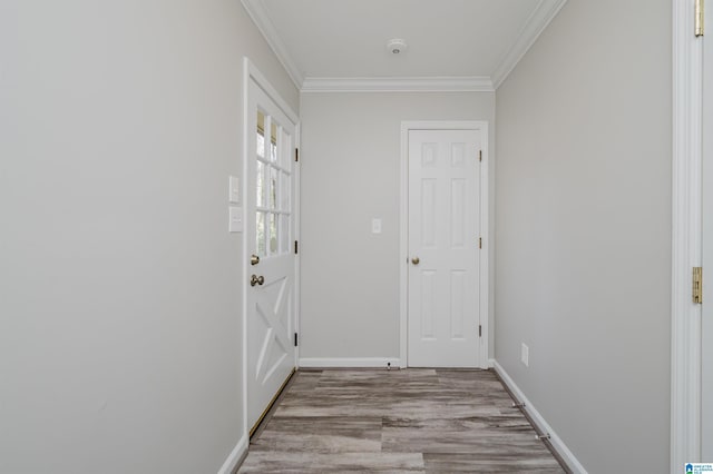 doorway to outside featuring light wood-style floors, baseboards, and ornamental molding