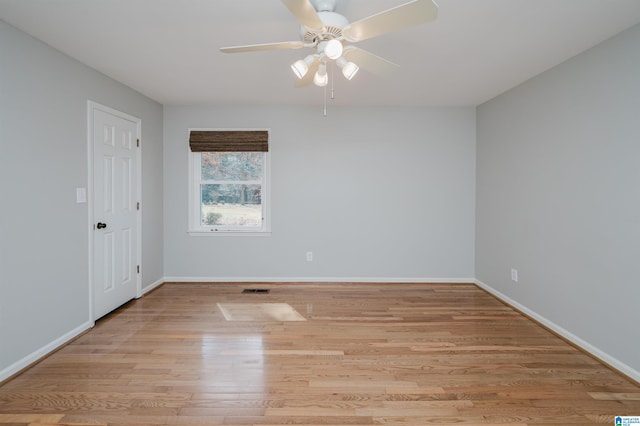 unfurnished room with baseboards, ceiling fan, visible vents, and light wood-style floors