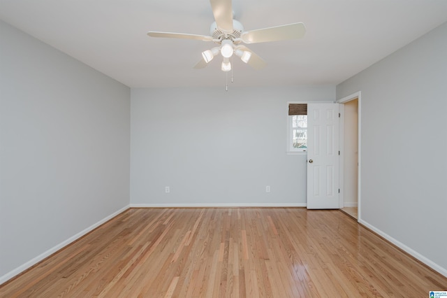 spare room with light wood-type flooring, baseboards, and a ceiling fan