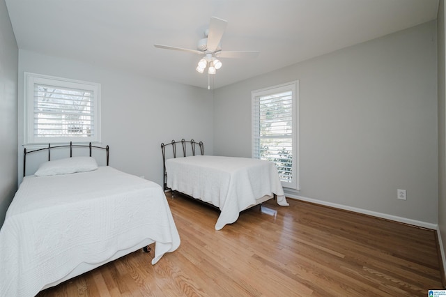 bedroom featuring ceiling fan, wood finished floors, and baseboards