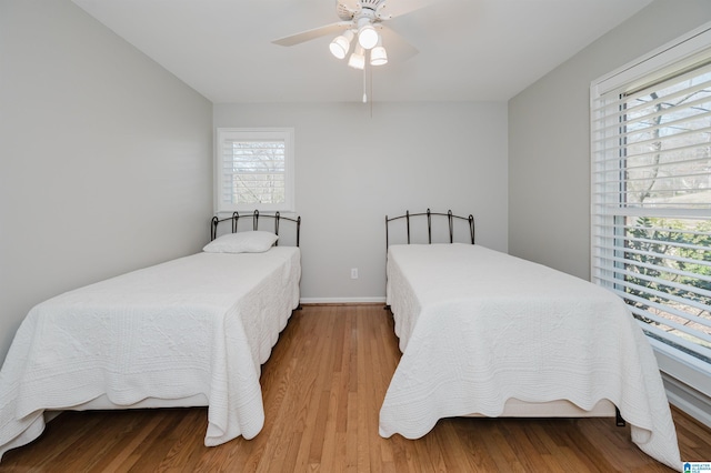 bedroom featuring ceiling fan, baseboards, and wood finished floors