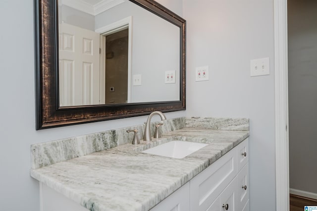 bathroom featuring crown molding, vanity, and baseboards