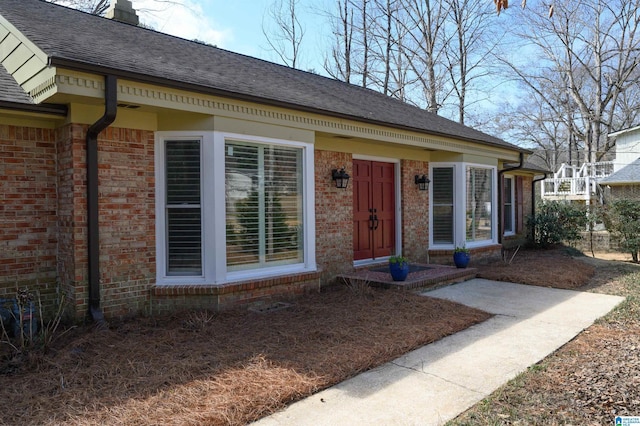 view of front of house featuring brick siding and a shingled roof