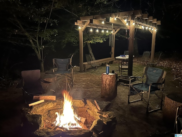 patio at twilight with an outdoor fire pit and a pergola