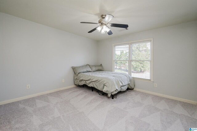 bedroom with light carpet, ceiling fan, and baseboards