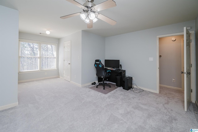 carpeted office with ceiling fan and baseboards