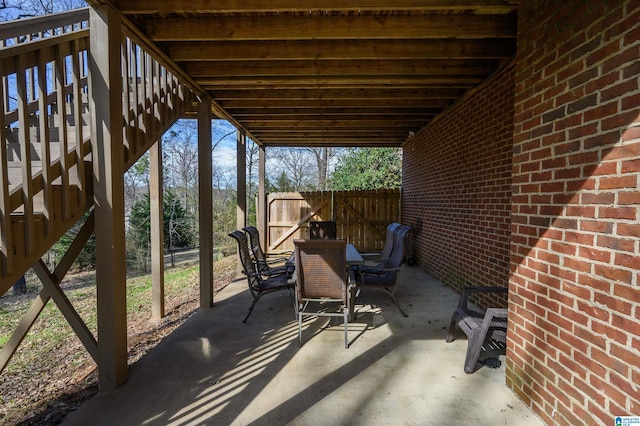 view of patio featuring stairway and fence