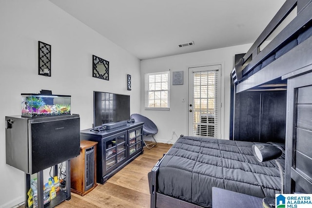 bedroom featuring visible vents, baseboards, and wood finished floors