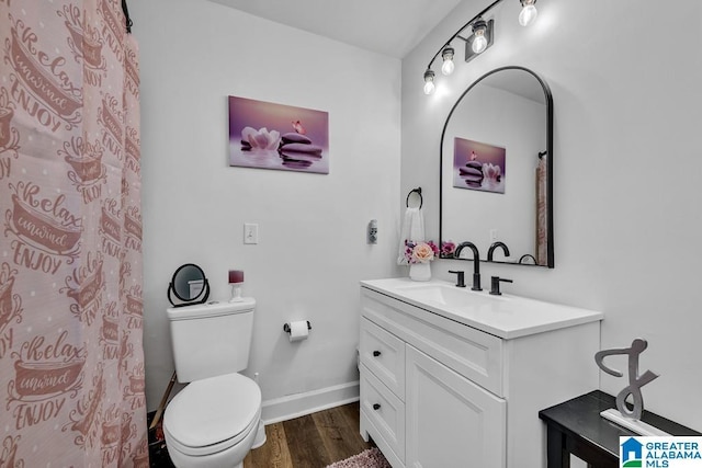 bathroom featuring vanity, wood finished floors, toilet, and baseboards