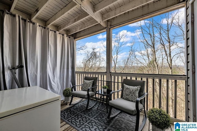 sunroom featuring beam ceiling, plenty of natural light, and wood ceiling