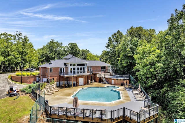 community pool with fence, a patio, and stairs